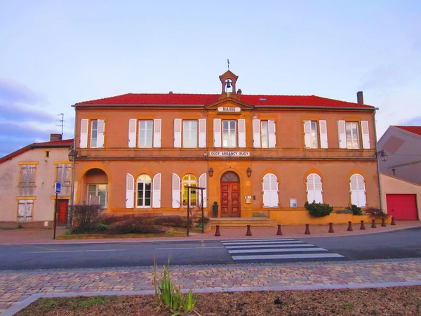 Une photographie d'une maison ou bâtiment résidentiel typique de la région de Moselle, avec vue de la façade principale et de l'entrée, illustrant l'environnement domestique ou professionnel où intervient l'Atelier des Sols & Fils pour la pose ou rénovation de sols. L'image doit montrer un bâtiment bien entretenu, de style régional, en contexte urbain ou périurbain de Lorraine, différent d'une vue générale de ville. Éviter les vues aériennes ou panoramiques, privilégier une perspective à hauteur d'homme montrant l'accueil du bâtiment.